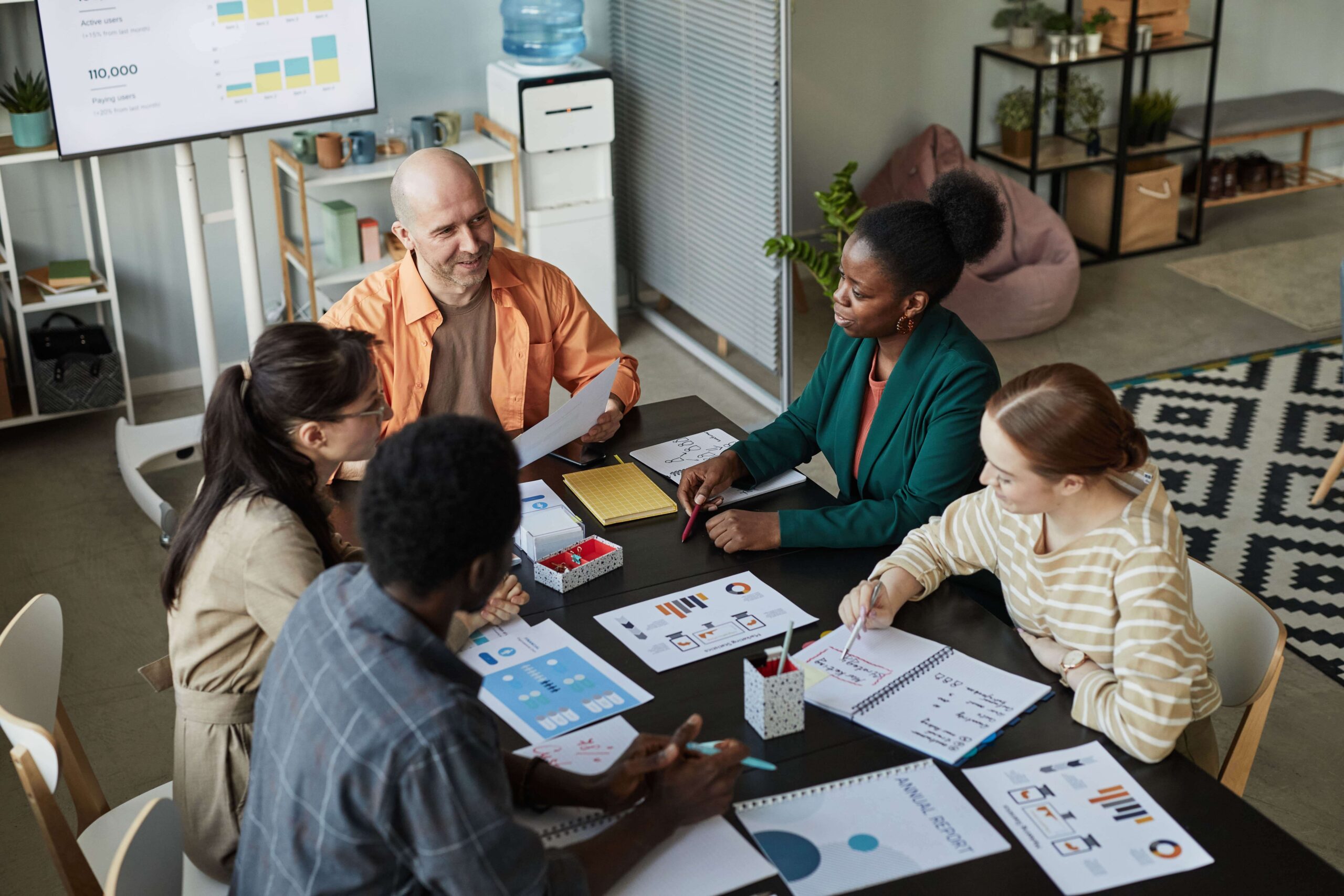 Members of a government agency sitting around a table discussing benefits management solutions.